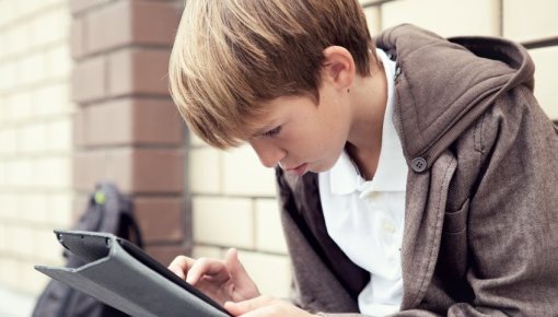 Photo of a teenage boy using a tablet device