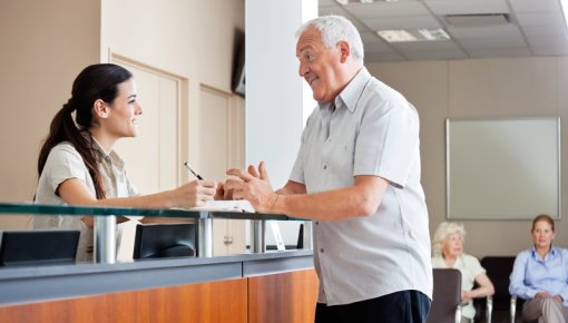 Photo of a patient and receptionist