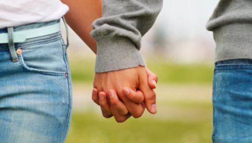 Photo of young couple holding hands