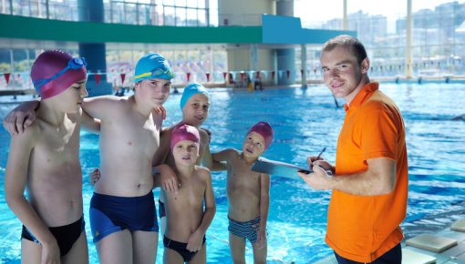 Photo of children in swimming caps at a swimming pool