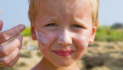 Photo of a young boy with sun lotion on his face