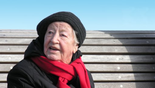 Photo of an elderly woman sitting on a bench