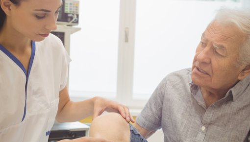 Photo of a doctor examining a man's knee