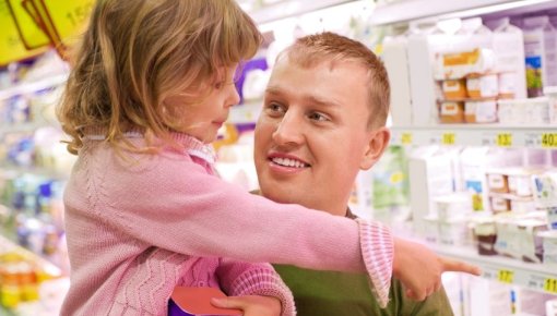 Photo of a father and daughter near the refrigerated foods section of the supermarket