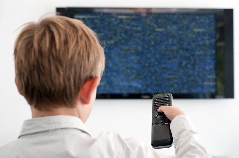 Boy switching a TV