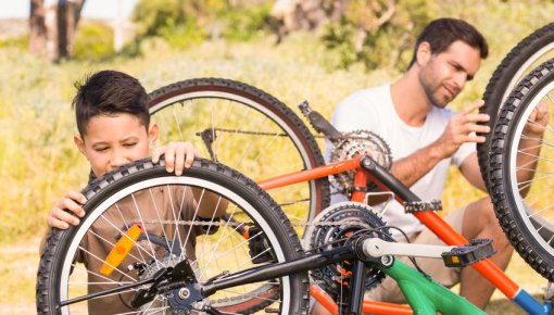 Photo of a father and his son repairing a bike