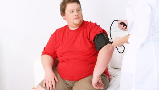 Photo of an overweight patient having his blood pressure measured