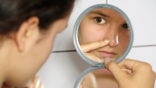 Photo of young woman looking into a mirror