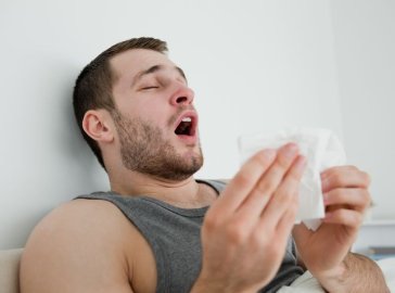 Photo of a man having a sneezing fit