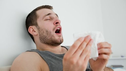 Photo of a man having a sneezing fit
