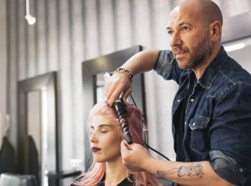 Photo of a hairdresser styling a woman’s hair