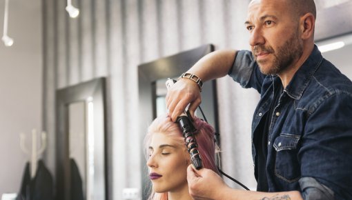 Photo of a hairdresser styling a woman’s hair