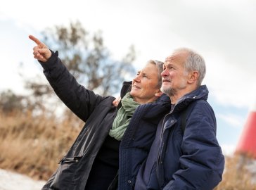 Photo of an older couple taking a walk on the beach