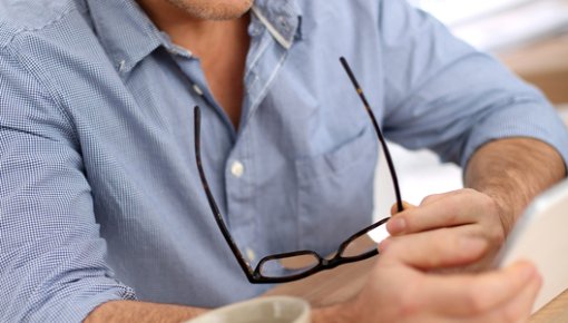 Photo of a man reading something on a tablet device