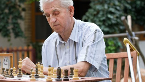 Photo of an older man playing chess