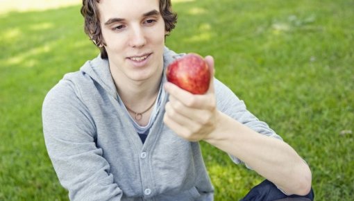 Photo of a teenager holding an apple