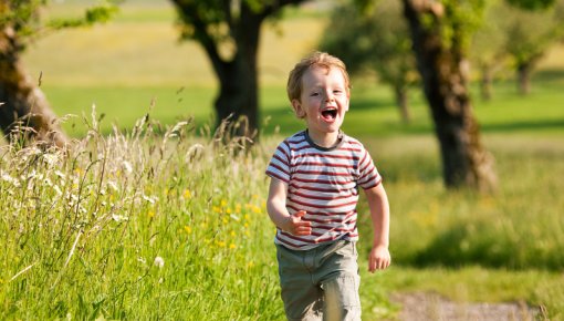 Photo of a young boy running across a field