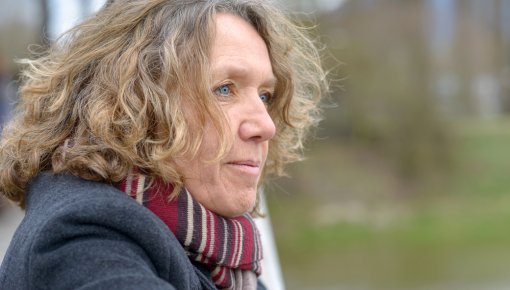 Photo of a woman with curly hair wearing a scarf outdoors