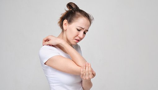 Young woman looking at bites on her forearm