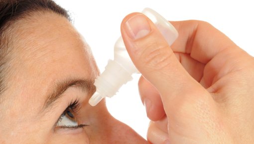 Photo of a woman using eye drops