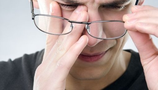 Photo of a man rubbing his eye