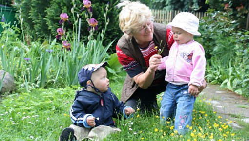 Photo of grandmother in a garden with her grandchildren