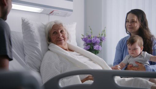 Photo of a family visiting their grandmother in the hospital