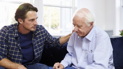 Photo of an elderly man talking with his son
