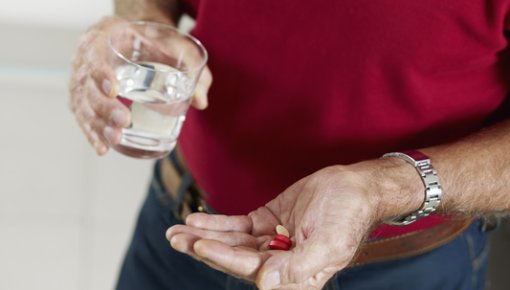 Photo of a man taking some pills