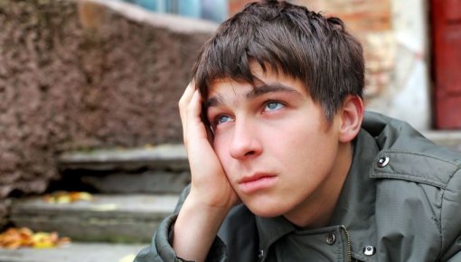Photo of a teenage boy looking upset
