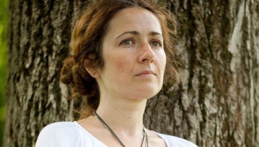 Photo of a woman sitting near a tree