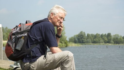 Photo of a man sitting at a lake