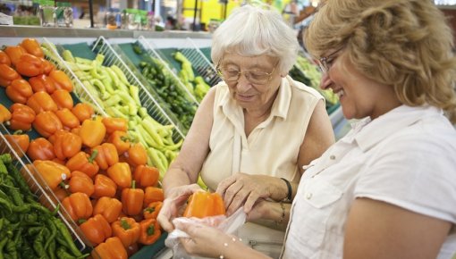 Photo of two women in the vegetable section of a supermarket