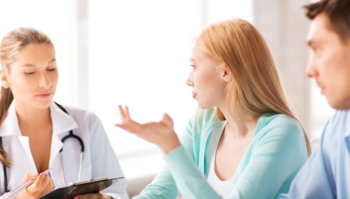 Photo of a couple talking to a doctor in a hospital