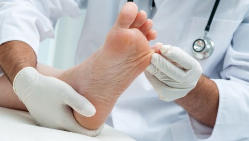 Photo of a dermatologist inspecting someone's foot