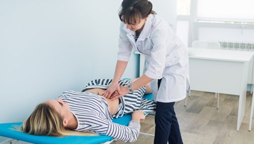 Photo of a doctor feeling a patient's belly