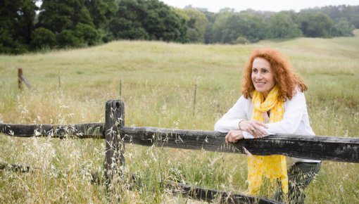 Photo of a woman leaning on a fence