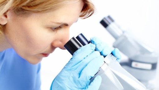 Photo of a woman looking through a microscope