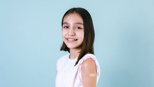 Photo of a girl with a patch on her upper arm.