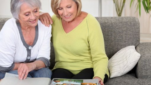 Photo of two women looking at a photo album