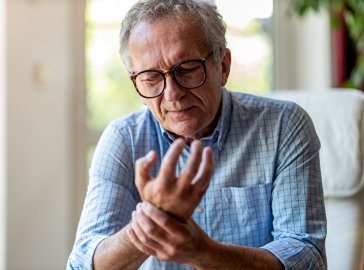 Photo of a man holding his hand in pain