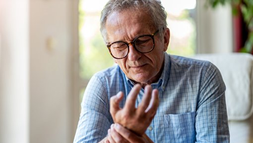 Photo of a man holding his hand in pain