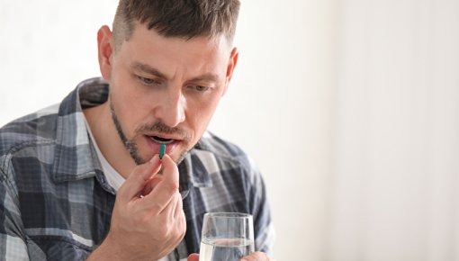 Photo of a man taking a tablet