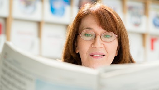 Photo of a woman reading a newspaper