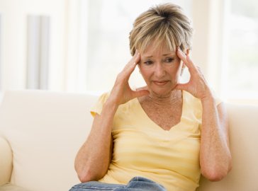 Photo of a woman holding her head in distress