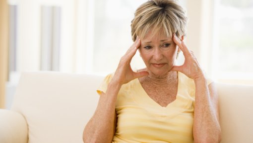 Photo of a woman holding her head in distress