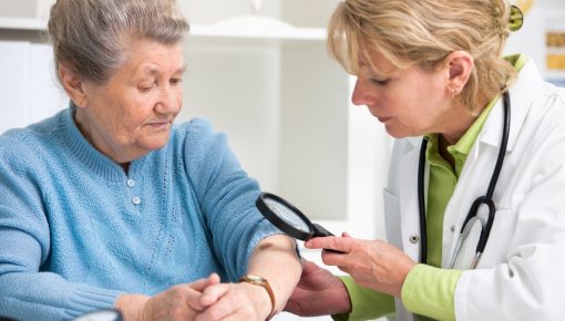 Photo of an older woman and doctor checking for unusual areas of skin