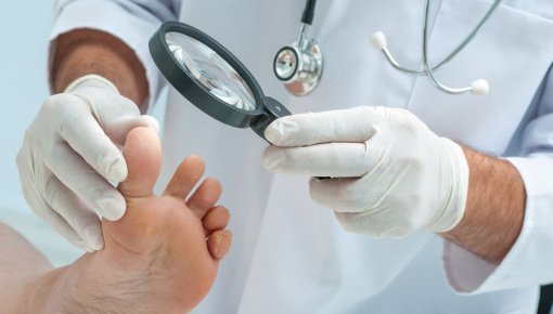Photo of a doctor inspecting someone’s toes for abnormalities