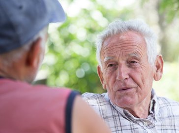 Photo of two elderly men talking outdoors