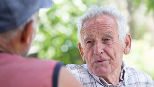 Photo of two elderly men talking outdoors